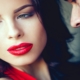 Close-up of a glamorous woman in red lips as a man whispers into her ear, symbolizing secret Vegas nightlife