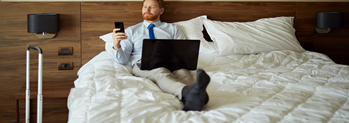 Man relaxing in upscale Vegas hotel room, preparing to book a companion