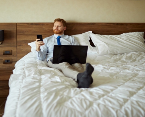 Man relaxing in upscale Vegas hotel room, preparing to book a companion
