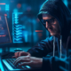 Man in hoodie and sunglasses typing on a laptop surrounded by digital code, working late in a dark tech room during DEF CON 32 in Las Vega
