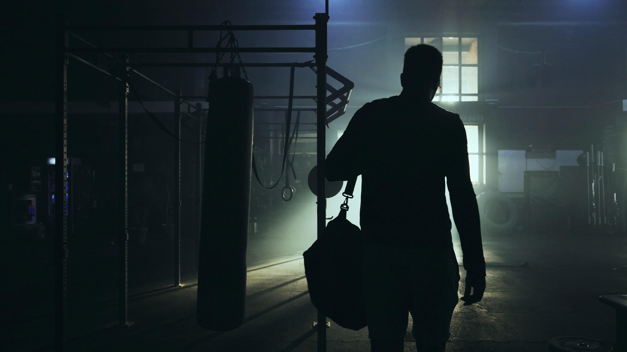 Dramatic silhouette of a boxer entering the gym, capturing the intensity and buildup to the Canelo vs Crawford Las Vegas 2025 superfight at Allegiant Stadium.